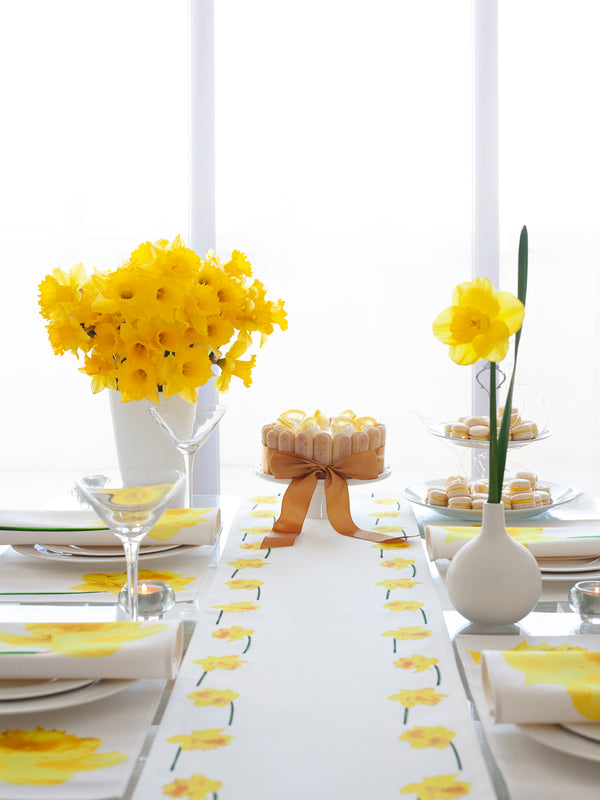 For a special occasions. Yellow daffodils table set with runner, napkins and placemats.