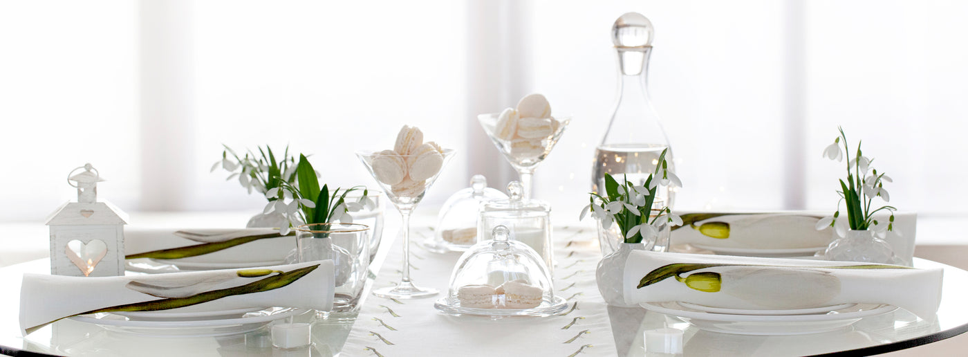 Luxury winter table setting featuring snowdrops table runner and napkins.
